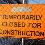Hinweisschild Temporarily closed for construction hinter Bauzaun